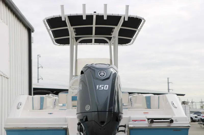 Slide: The Image of Robalo R200 Center Console from 2027 with a 150-hp outboard motor, parked next to a building. - 18