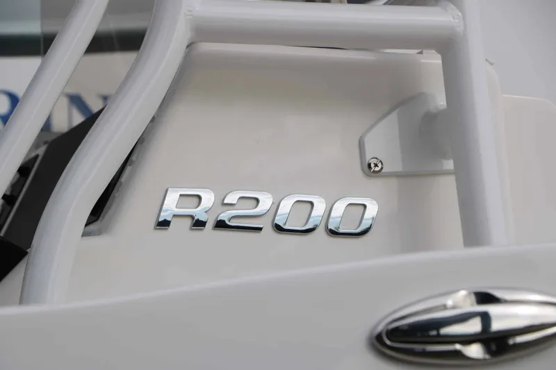 Slide: The Image of Close-up of the R200 logo on a white boat. - 23