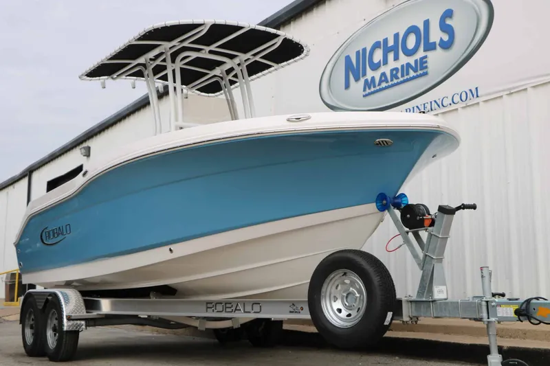 Slide: The Image of A 2027 Robalo R200 Center Console boat on a trailer in front of a building. - 8
