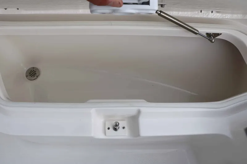 Slide: The Image of An open storage compartment with a drain and gas strut in a boat. - 35