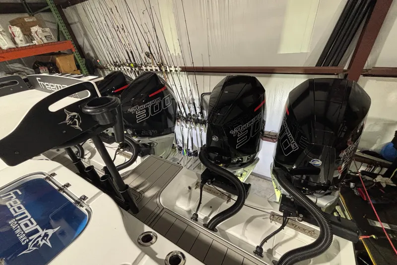 Slide: The Image of Four powerful outboard motors on a 2025 Freeman 38 boat, with fishing rods in the background. - 21