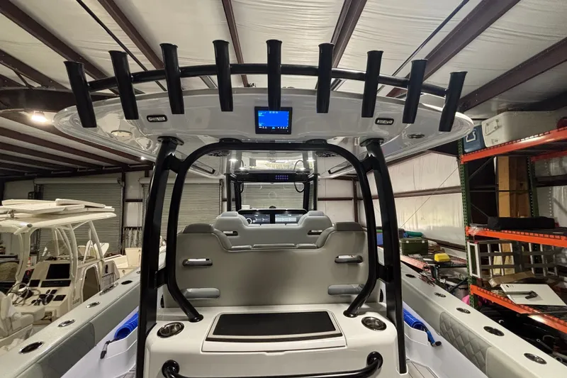 Slide: The Image of 2025 Freeman 38 boat interior with rod holders and modern dashboard in a warehouse setting. - 17