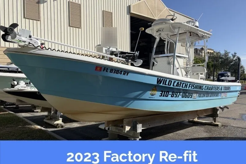 Slide: The Image of 2007 Andros 26 Tarpon with blue hull, on a trailer, featuring advertising decals and 2023 refit notice. - 1