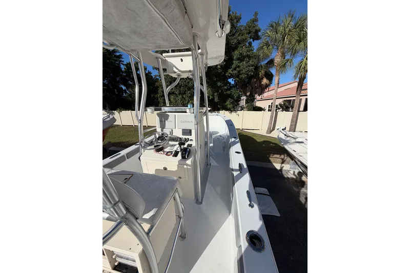 Slide: The Image of 2007 Andros 26 Tarpon boat interior with steering console and seating, surrounded by palm trees. - 12