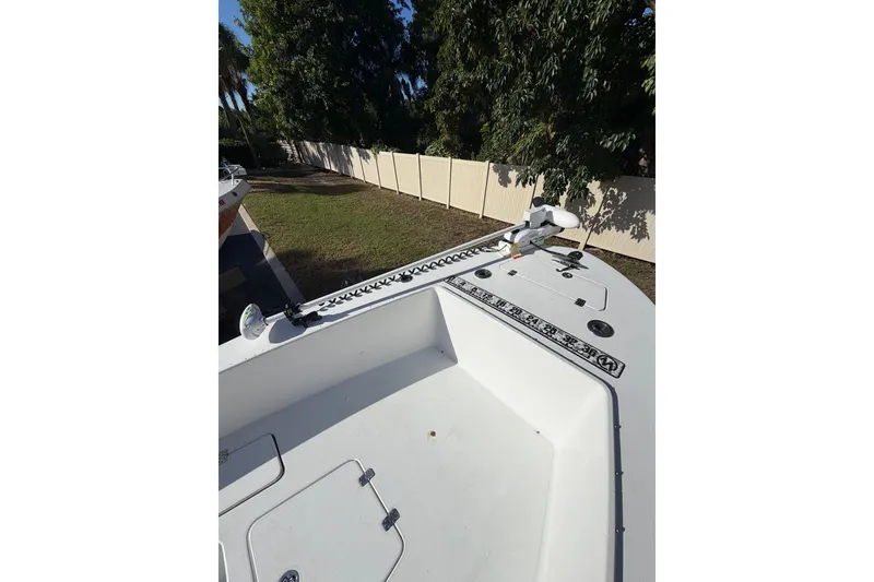 Slide: The Image of 2007 Andros 26 Tarpon boat deck with trolling motor, surrounded by trees and fence. - 19