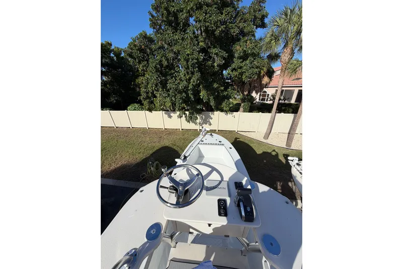 Slide: The Image of 2007 Andros 26 Tarpon boat helm with steering wheel and controls, surrounded by trees. - 16