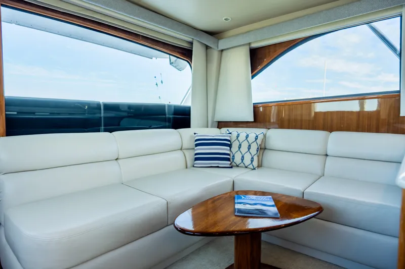 Slide: The Image of Luxurious interior of 2005 Viking 45 Convertible yacht with white leather seating and wooden table. - 24