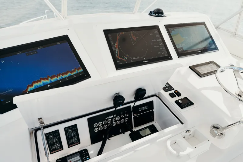 Slide: The Image of Control panel of a 2005 Viking 45 Convertible yacht with navigation screens and steering wheel. - 15