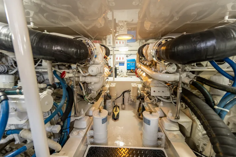 Slide: The Image of Engine room of a 2005 Viking 45 Convertible yacht, showcasing complex machinery and piping. - 34