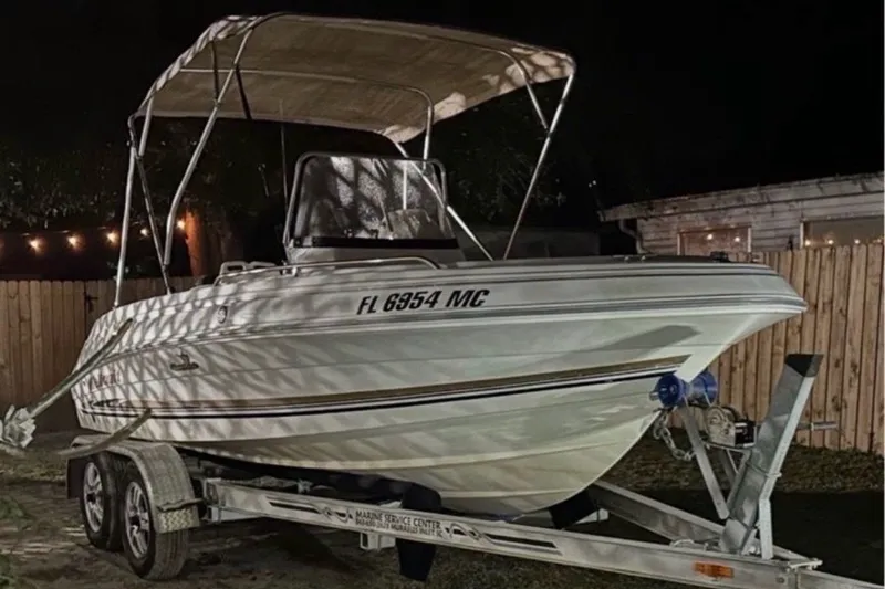 The Image of 2003 Wellcraft 200 Fisherman boat on trailer at night, with canopy and registration number visible. - 0