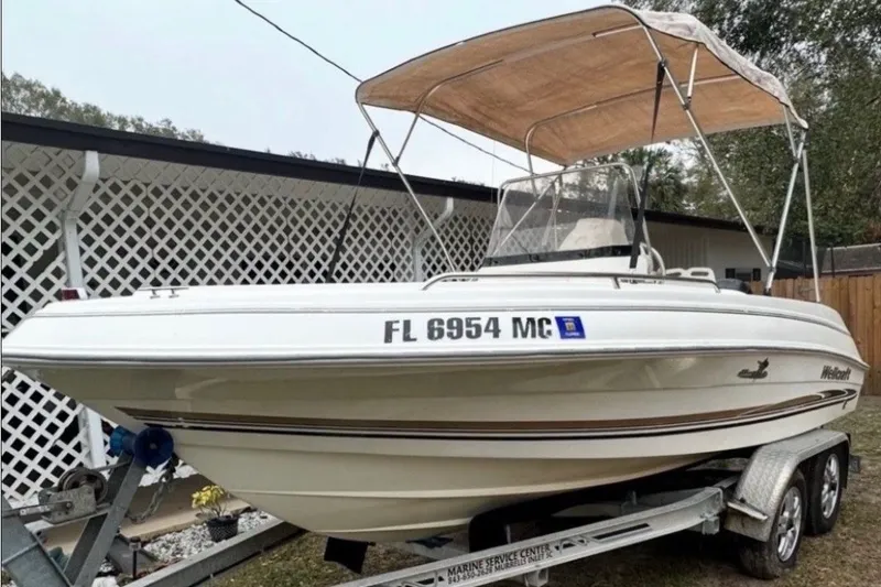 Slide: The Image of 2003 Wellcraft 200 Fisherman boat on trailer with canopy, parked outdoors. - 1