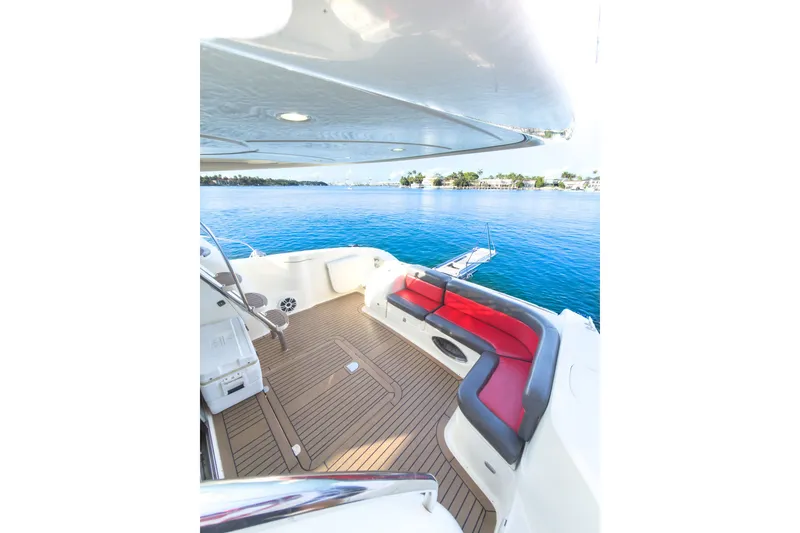 Slide: The Image of Luxurious 2002 Cranchi Atlantique 50 yacht deck with red seating, overlooking serene blue waters. - 6
