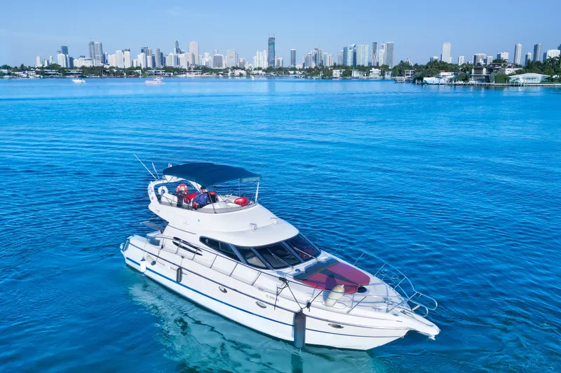 Slide: The Image of Cranchi Atlantique 50 yacht on blue water with city skyline in background, 2002 model. - 4