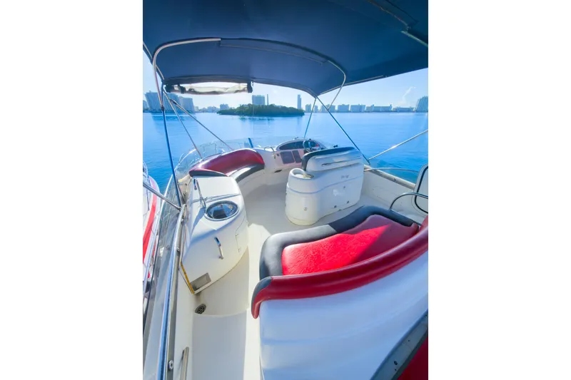 Slide: The Image of Luxurious 2002 Cranchi Atlantique 50 yacht interior with red seating, overlooking serene blue waters. - 9