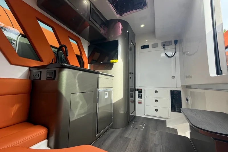 Slide: The Image of Interior of 2025 Midnight Express 43 Solstice boat with modern amenities and orange accents. - 13