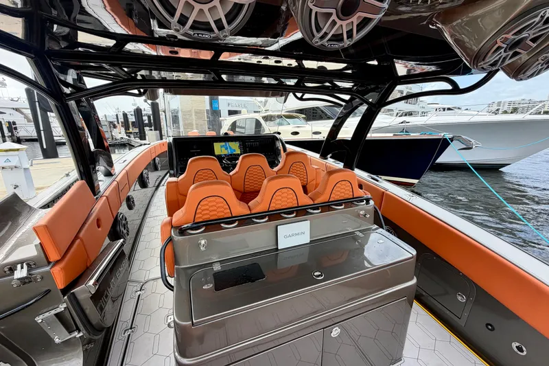 Slide: The Image of Interior of 2025 Midnight Express 43 Solstice boat with orange seating and advanced navigation system. - 4
