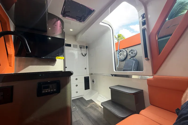 Slide: The Image of Interior of 2025 Midnight Express 43 Solstice boat with modern amenities and orange seating. - 14