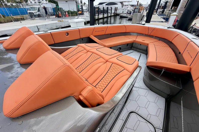 Slide: The Image of Luxurious orange seating on 2025 Midnight Express 43 Solstice boat, docked at marina. - 8