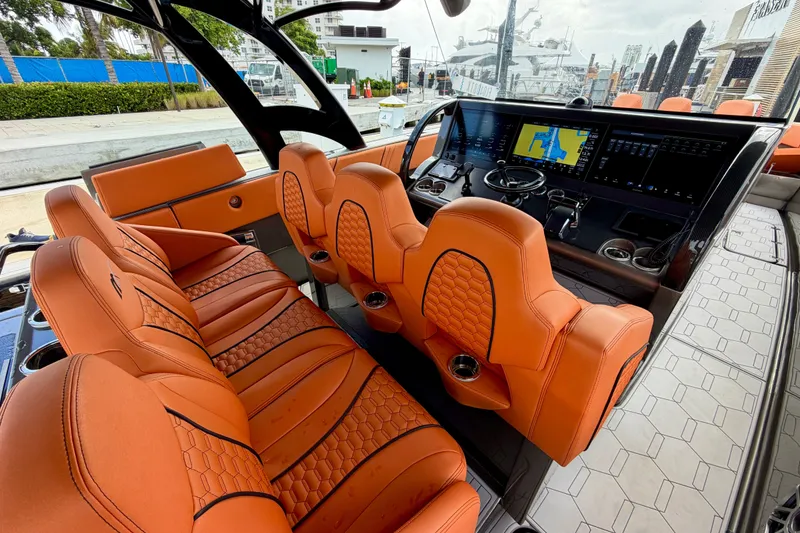 Slide: The Image of Luxurious interior of 2025 Midnight Express 43 Solstice boat with orange seating and advanced dashboard. - 2