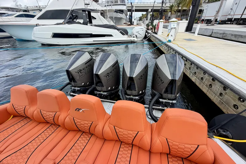 Slide: The Image of 2025 Midnight Express 43 Solstice with quad engines and luxurious orange seating at a marina. - 7