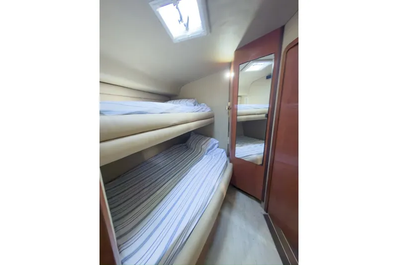 Slide: The Image of 1997 Sea Ray 500 Sundancer cabin with bunk beds and mirrored door. - 16