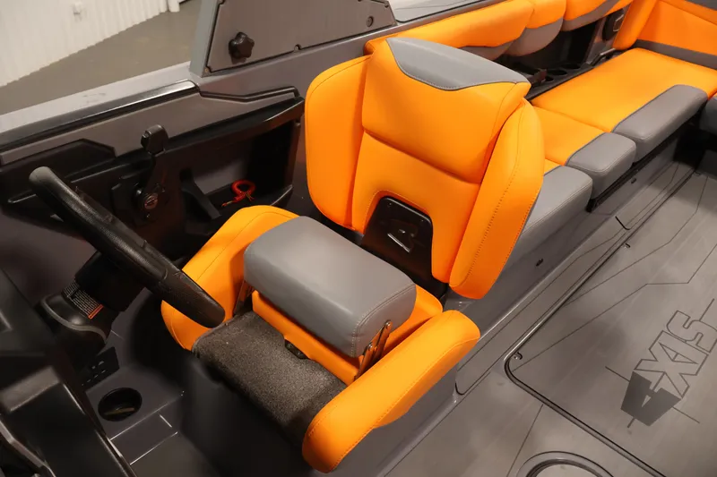 Slide: The Image of 2025 Axis T250 boat interior with orange and gray seating, steering wheel, and modern design. - 26