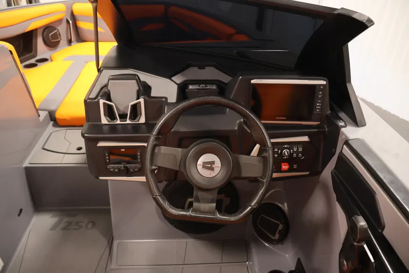 Slide: The Image of 2025 Axis T250 boat dashboard with steering wheel, touchscreen, and orange seating. - 18