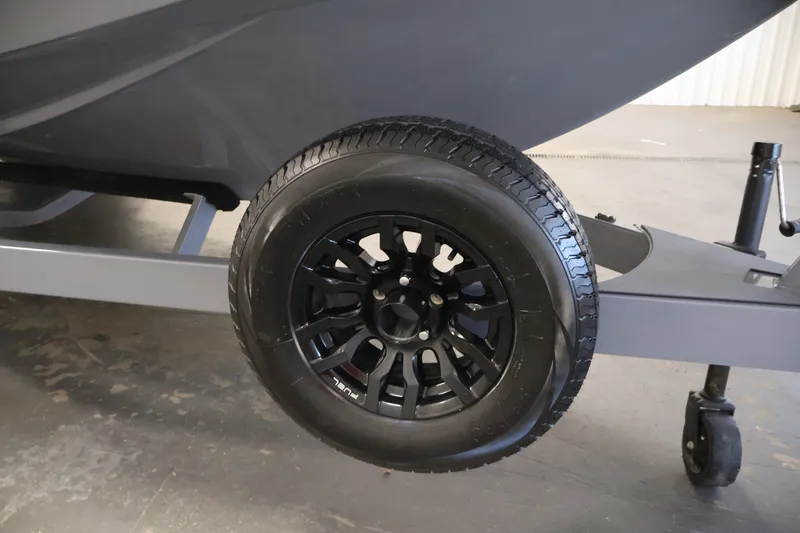 Slide: The Image of 2025 Axis T250 trailer wheel with black alloy rim in a garage setting. - 52