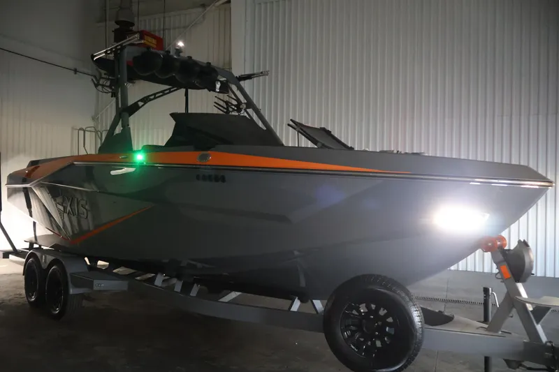 Slide: The Image of 2025 Axis T250 boat on trailer in a dimly lit indoor setting. - 59