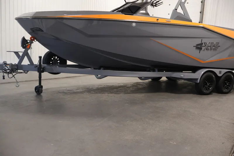 Slide: The Image of 2025 Axis T250 boat on trailer, gray with orange accents, in indoor setting. - 53