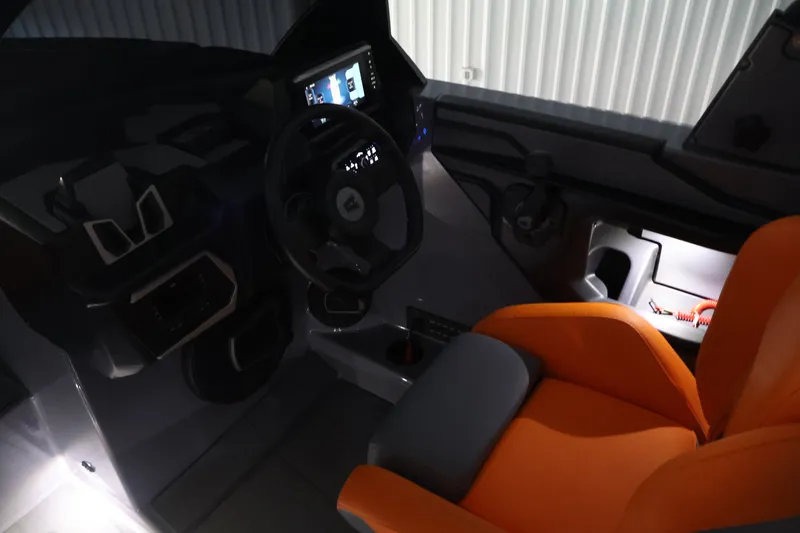 Slide: The Image of Interior of 2025 Axis T250 boat with modern dashboard and orange seating. - 63