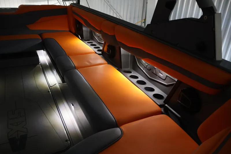 Slide: The Image of Interior of 2025 Axis T250 boat with orange and gray seating, illuminated cup holders. - 64