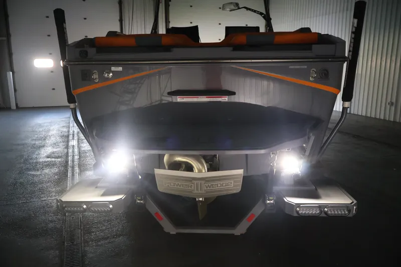 Slide: The Image of 2025 Axis T250 boat rear view with illuminated lights in a garage setting. - 60