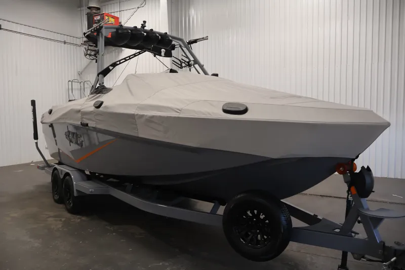 Slide: The Image of 2025 Axis T250 boat covered on trailer in indoor storage facility. - 57