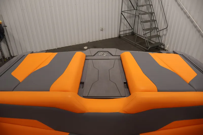 Slide: The Image of 2025 Axis T250 boat interior with orange and gray seating, in a storage facility. - 41