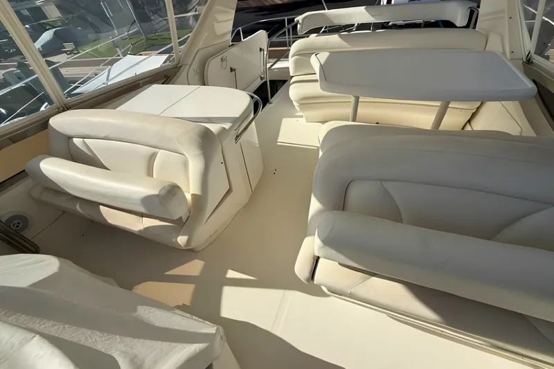 Slide: The Image of Luxurious interior of 2000 Sea Ray 560 Sedan Bridge yacht with white seating and table. - 9