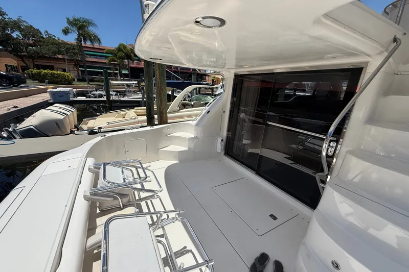 Slide: The Image of 2000 Sea Ray 560 Sedan Bridge yacht deck with seating, docked at marina. - 5