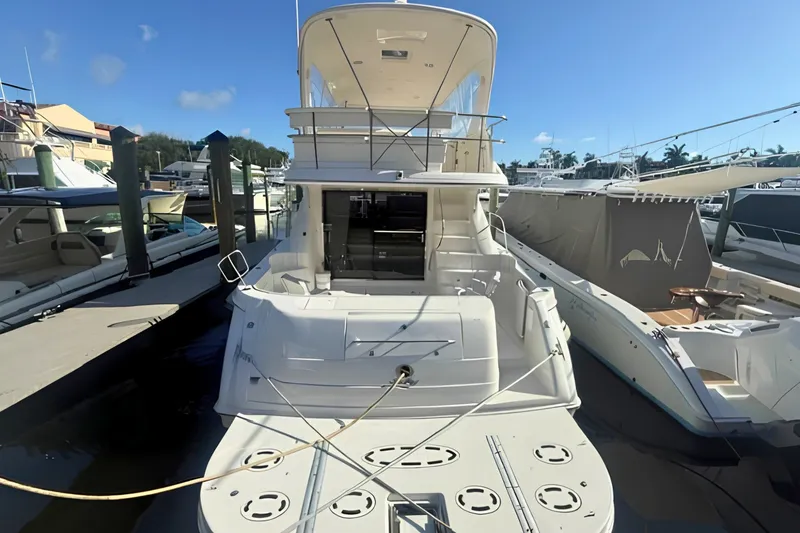 Slide: The Image of 2000 Sea Ray 560 Sedan Bridge yacht docked at marina under clear blue sky. - 3