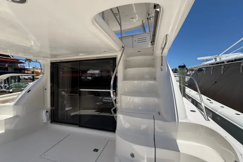 Slide: The Image of 2000 Sea Ray 560 Sedan Bridge yacht with sleek white exterior and staircase to upper deck. - 6