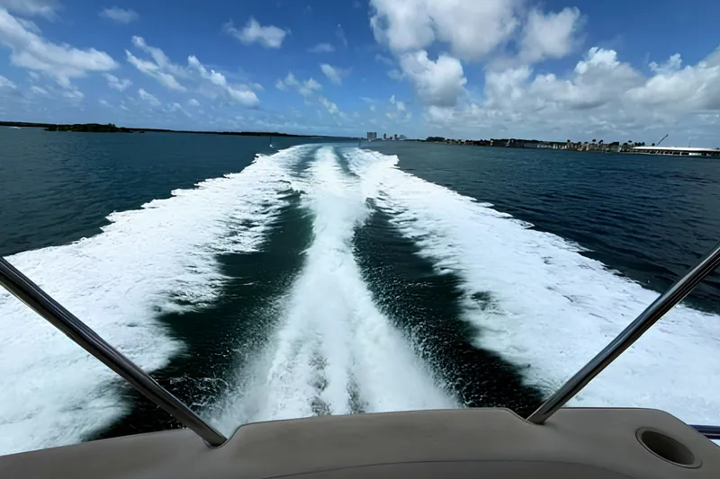 Slide: The Image of Wake trail behind 2000 Sea Ray 560 Sedan Bridge on open water under blue sky. - 21