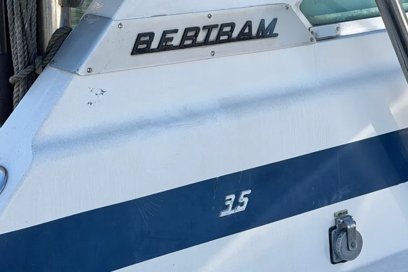 Slide: The Image of 1971 Bertram 35 Sport Fisherman boat exterior with logo and blue stripe. - 14