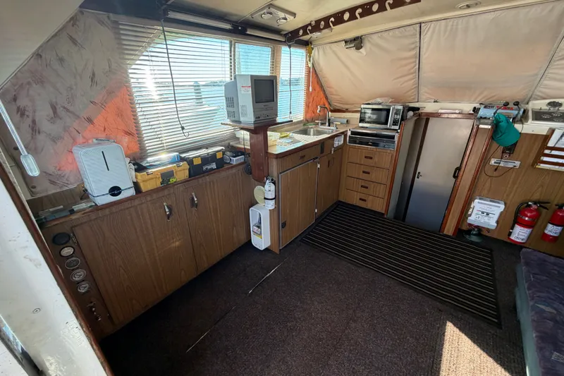 Slide: The Image of Interior of a 1971 Bertram 35 Sport Fisherman boat with kitchen amenities. - 17