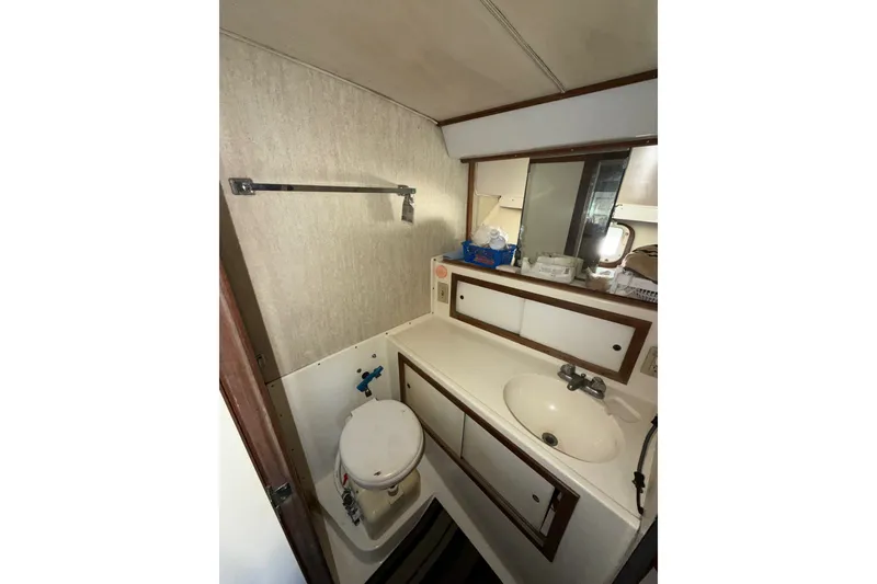 Slide: The Image of 1971 Bertram 35 Sport Fisherman boat bathroom with sink, toilet, and storage cabinets. - 31