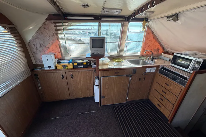 Slide: The Image of 1971 Bertram 35 Sport Fisherman interior with kitchen appliances and wooden cabinetry. - 18