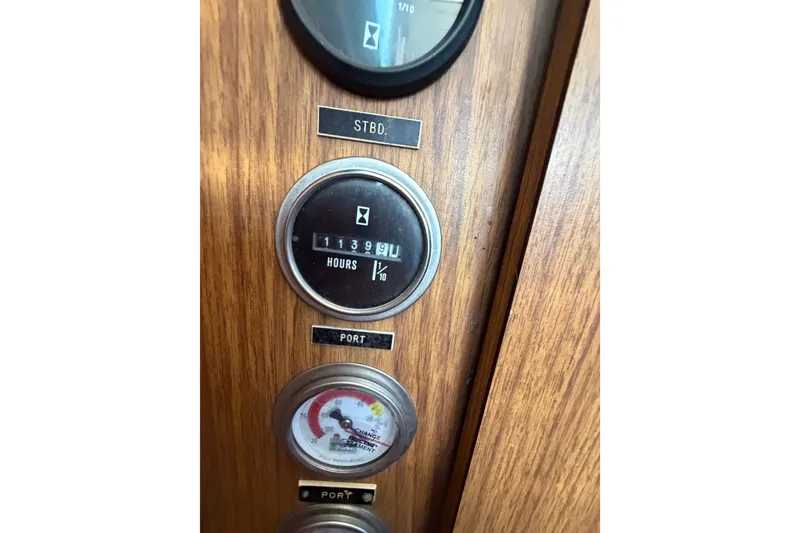 Slide: The Image of 1971 Bertram 35 Sport Fisherman dashboard with hour meter and gauge on wood panel. - 36