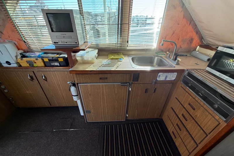 Slide: The Image of 1971 Bertram 35 Sport Fisherman interior with kitchenette, sink, and vintage TV. - 21