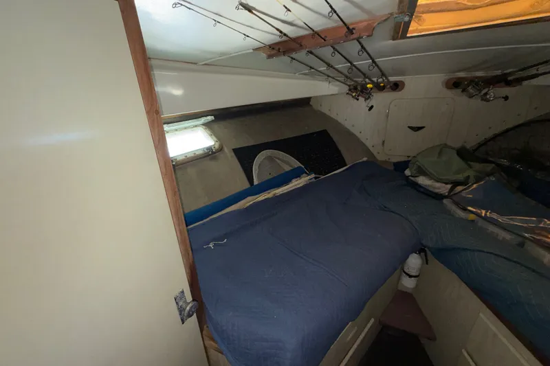 Slide: The Image of 1971 Bertram 35 Sport Fisherman cabin with fishing rods and blue bedding. - 26
