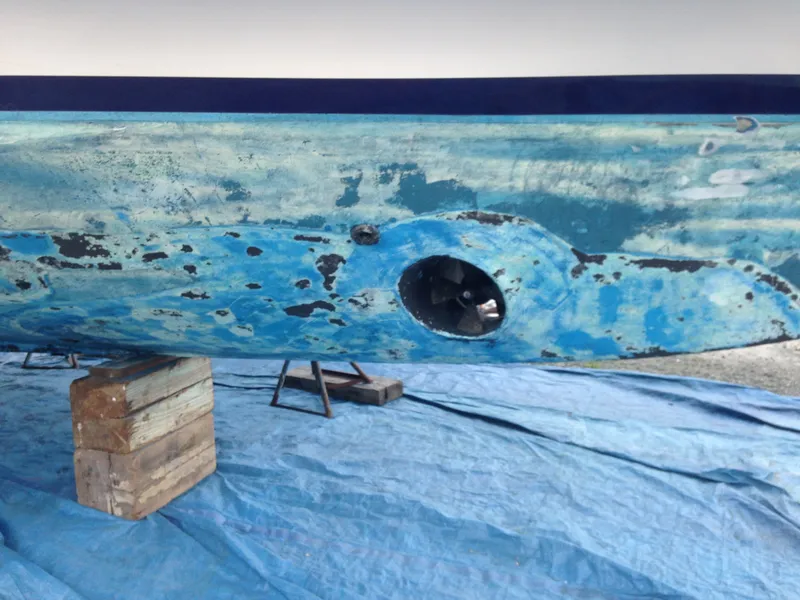 Slide: The Image of The hull of a 1988 Ocean Alexander 546 Cockpit Motoryacht is propped up and being painted. - 22