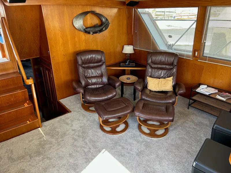 Slide: The Image of Cozy salon with two brown leather chairs and a small table, surrounded by wood paneling. - 14