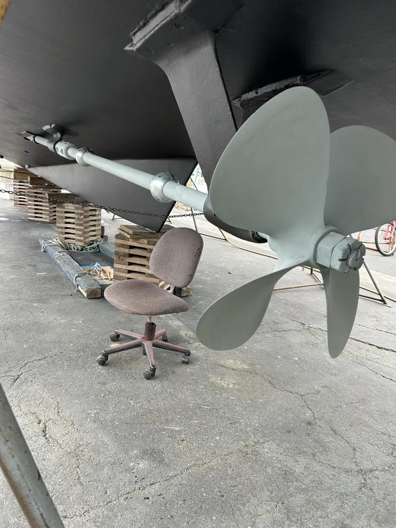 Slide: The Image of A large boat with a gray propeller and an office chair nearby. - 31